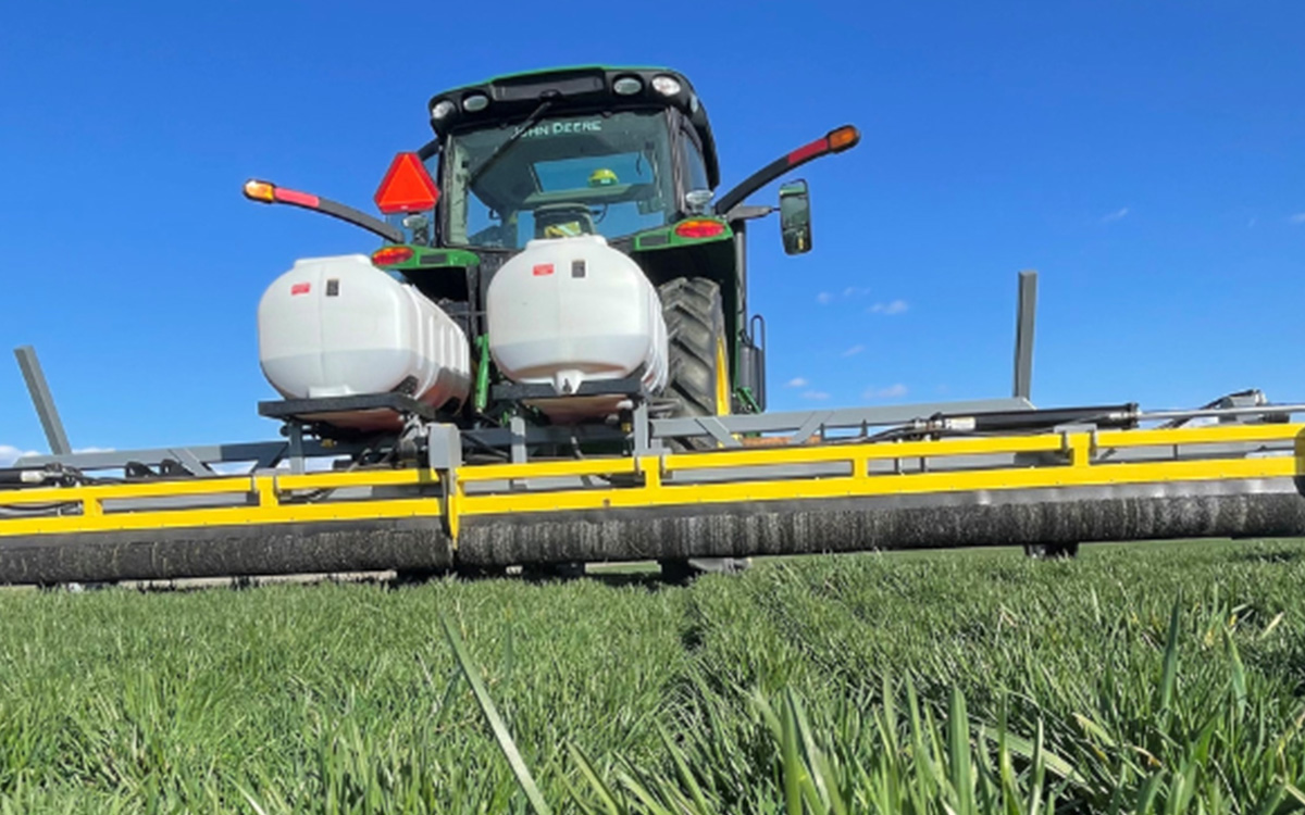 A GrassWorks 3-Point Tractor Mount Weed Wiper attached to a tractor in a field, demonstrating precision weed control for farmers.