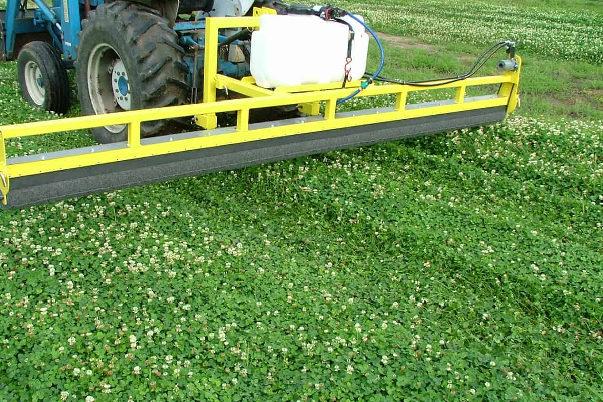 A GrassWorks 3-point tractor-mounted Weed Wiper demonstrating its ability to apply herbicide selectively while reducing chemical drift in pastures.