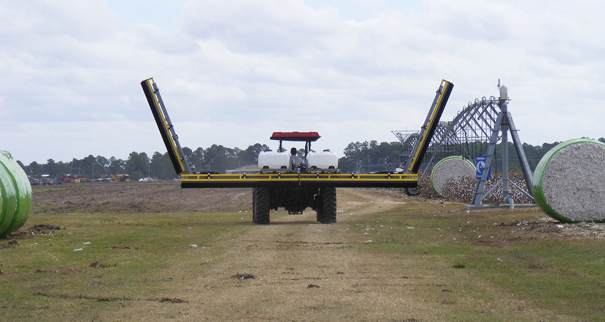 A GrassWorks Flex Unit Weed Wiper in action, mounted on a tractor for targeted herbicide application in pastures.